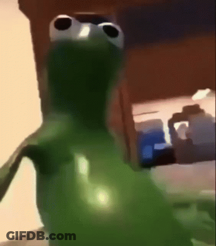 Green Frog With Big Eyes Standing In Front Of Table GIF