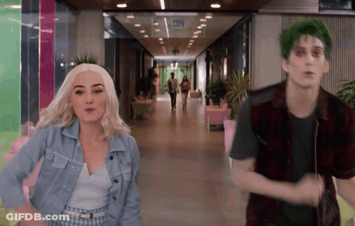 Green-Haired Man Next To Woman In Hallway GIF