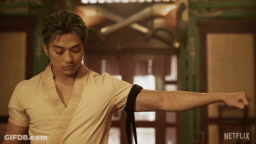 Green-Haired Man Standing In Front Of Netflix Ad GIF