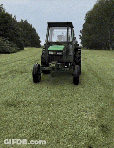 Green John Deere Tractor Driving Through Field GIF