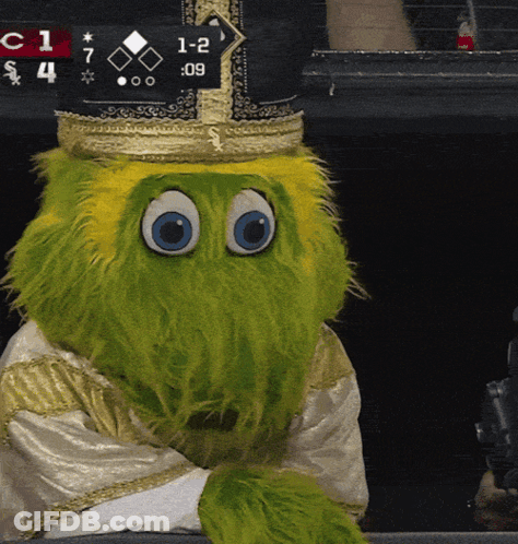 Green Mascot In Crown Sitting In Front Of Scoreboard Saying 1-2 GIF