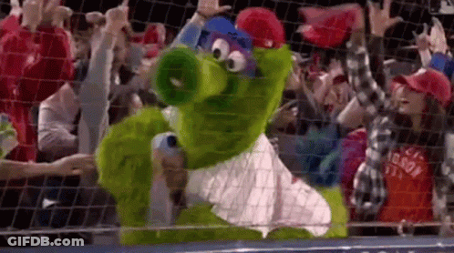 Green Mascot Standing In Front Of Crowd GIF