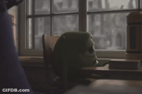 Green Monster Sitting At Desk Looking Out Window GIF