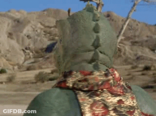 Green Monster With Horns And Scarf In Desert GIF