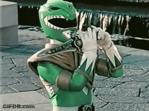 Green Power Ranger Holding Gun On Brick Sidewalk GIF