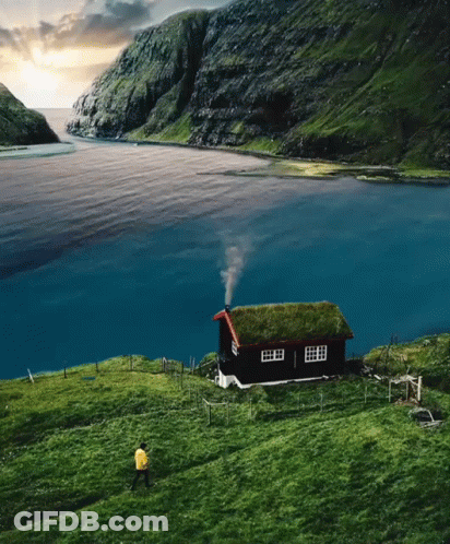 Green Roof House With Chimney Smoke In Field GIF