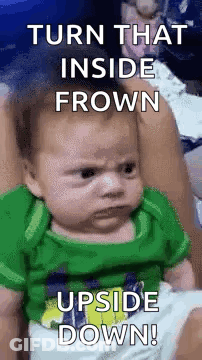 Green Shirt Baby Making Funny Face In Woman's Arms GIF
