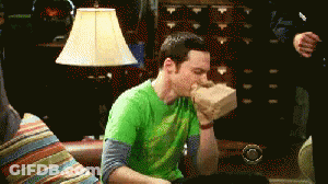 Green Shirt Man Hand In Mouth On Couch GIF