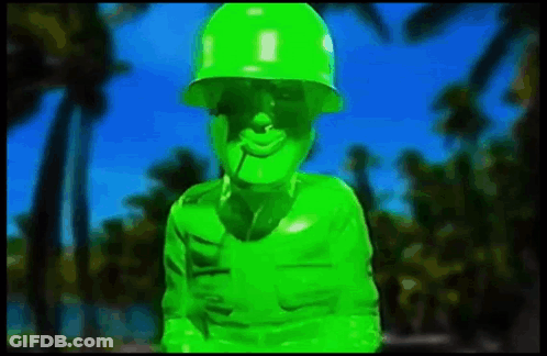 Green Soldier With Cigarette Standing In Front Of Palm Tree GIF