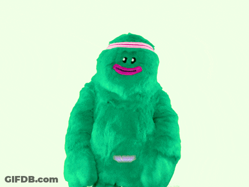 Green Stuffed Animal With Pink Headband Saying We Move GIF