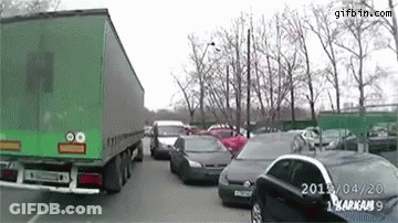 Green Truck Driving Through Parking Lot GIF