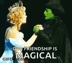 Green Woman In Top Hat And Blue Dress Woman Holding Hands GIF