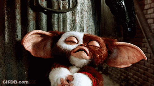 Gremlin Holding Glass Bottle In Mouth GIF