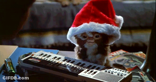 Gremlin In Santa Hat Sitting On Keyboard GIF