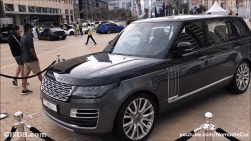 Grey Range Rover Parked With People Standing Around GIF