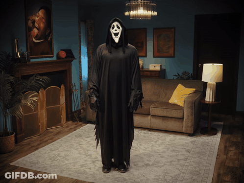Grim Reaper Costume Standing In Living Room GIF