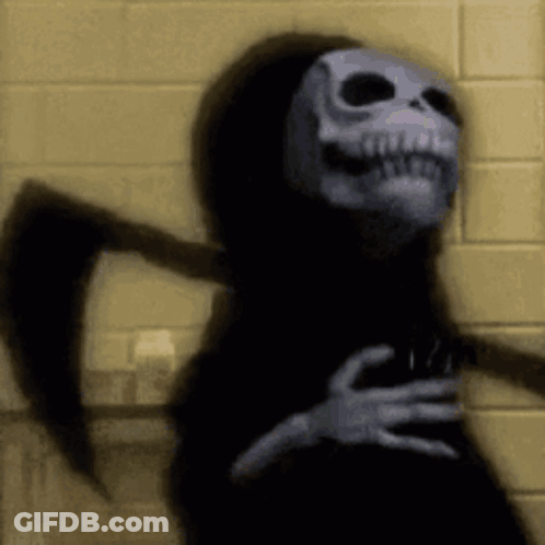 Grim Reaper With Scythe In Front Of Yellow Brick Wall GIF