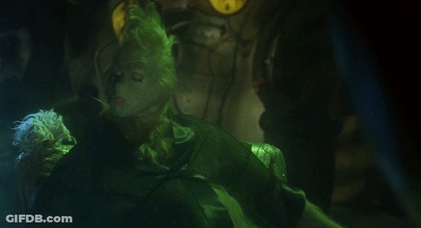 Grinch Close Up In Dark Room With Clock GIF