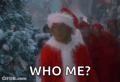 Grinch Is Standing In Front Of A Christmas Tree Wearing A Santa Hat And Saying `` Who Me ? '' . GIF