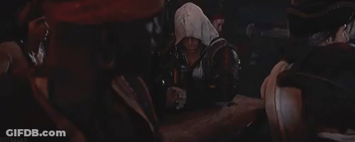 Group Around Table In Dark Room, One Hooded GIF