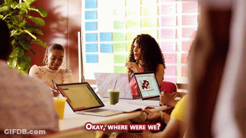 Group Around Table With Laptops Asking Where Were We GIF