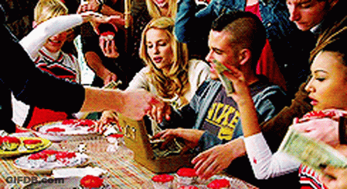 Group Around Table With Man In Nike Sweatshirt GIF