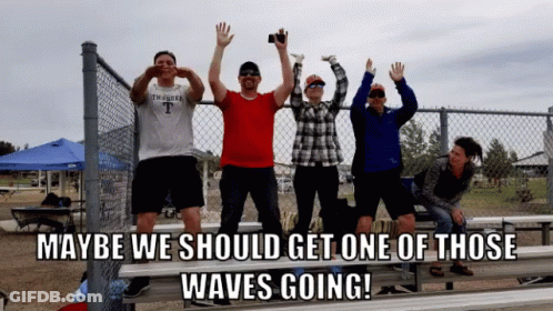 Group Behind Chain Link Fence Saying Maybe We Should Get One Of Those Waves Going GIF