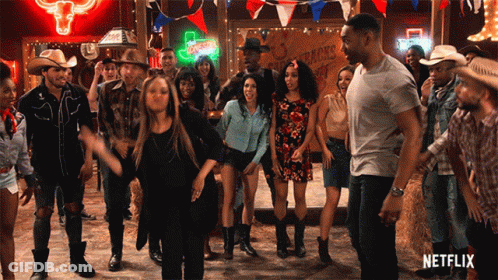 Group Dancing In Front Of Cowboys Sign GIF