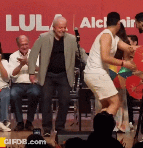 Group Dancing In Front Of Red Lula Sign GIF