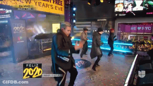 Group Dancing In Front Of Year's Eve Sign GIF