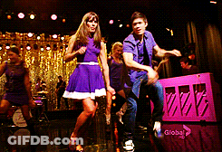 Group Dancing On Stage In Front Of Global Logo GIF