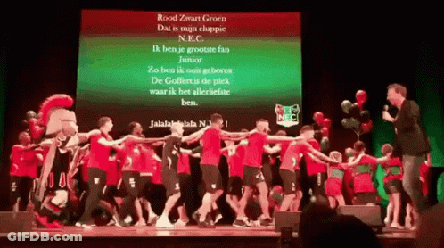 Group Dancing On Stage In Front Of Rood Zwart Groen Screen GIF