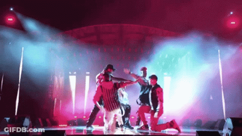 Group Dancing On Stage In Pink And Blue Lights GIF