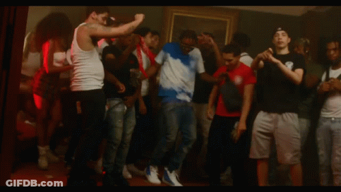 Group Dancing With Man In Tie Dye Shirt With Letter S GIF
