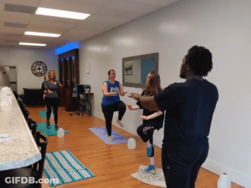 Group Doing Yoga Under Wall Clock GIF