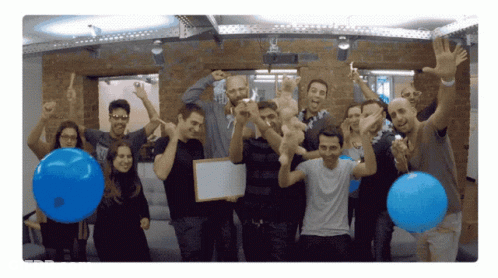 Group Holding Blue Balloons And Whiteboard GIF