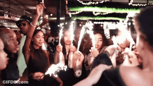 Group Holding Sparklers At Party GIF
