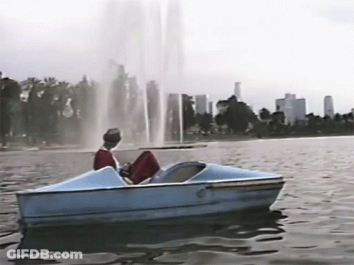 Group In Bikinis Riding Boat On Lake GIF
