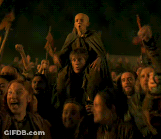 Group In Dark Room Holding Child On Shoulders GIF