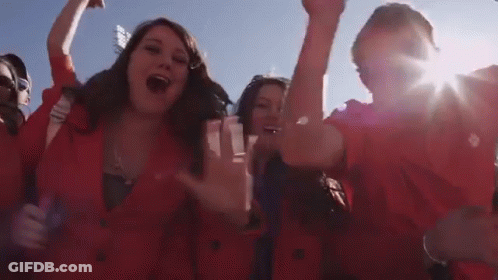 Group In Red Jackets Cheering With Hands Up GIF