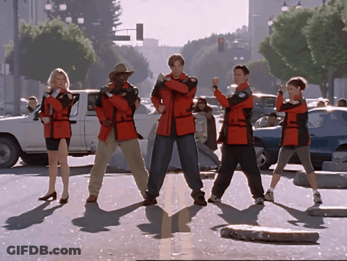 Group In Red Jackets On Street Corner GIF
