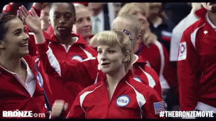 Group In Red Jackets Standing In Crowd GIF