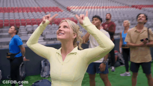 Group In Stadium Woman Pointing Up GIF