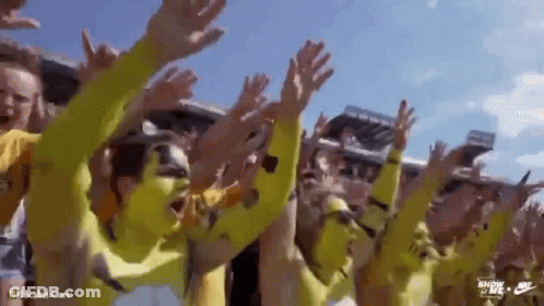 Group In Yellow Shirts Raising Hands GIF