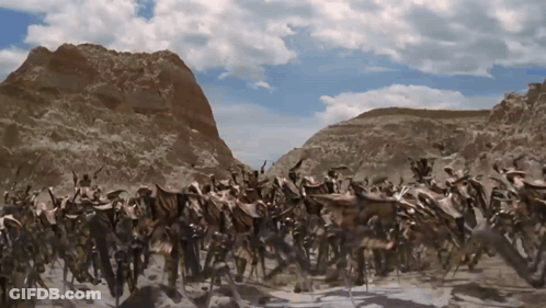 Group Of Animals In Desert With Mountains GIF