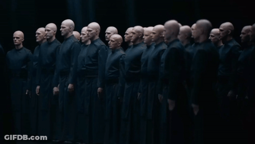 Group Of Bald Men In Black Uniforms Standing In Line GIF