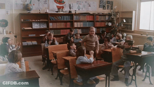 Group Of Children In Classroom With Merry Christmas Sign GIF