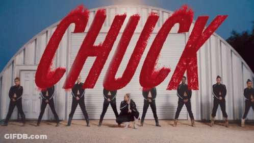 Group Of Dancers In Front Of Sign Saying Chuck GIF