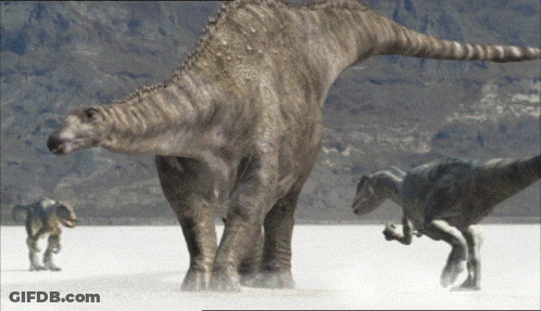 Group Of Dinosaurs Standing On Sand GIF