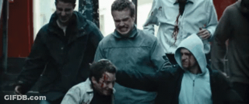Group Of Men Around Man With Blood On Face GIF